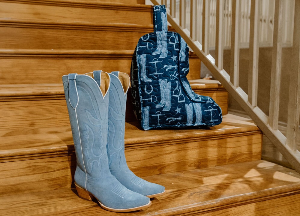 Una bolsa para botas Ida Mae y una bota Tony Lama sobre unos escalones de madera.