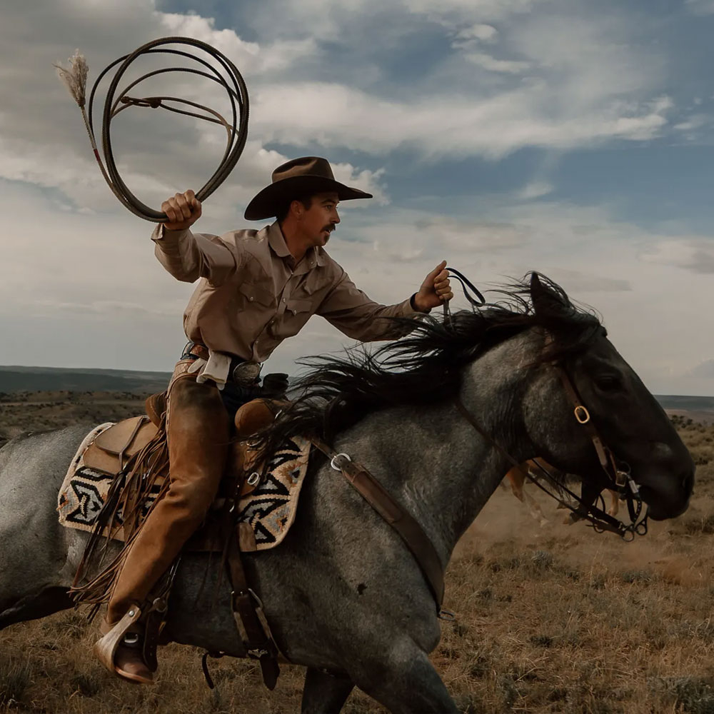 Man riding a horse wearing Samuel 13" Western in tan.