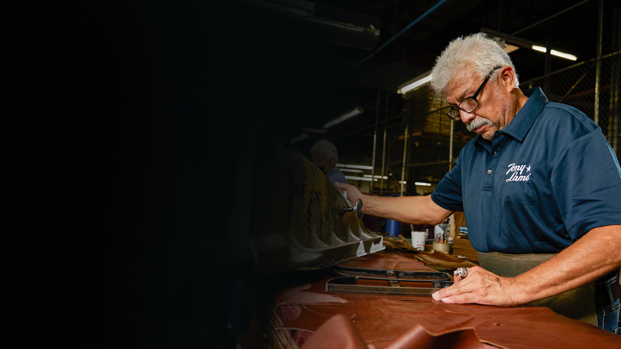 Factory worker stamps a template for boot out of leather.