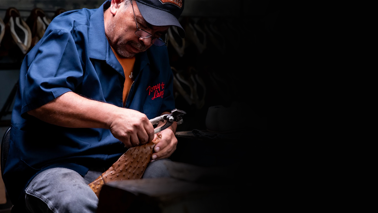 Factory worker stretches leather over a last for a Tony Lama boot.
